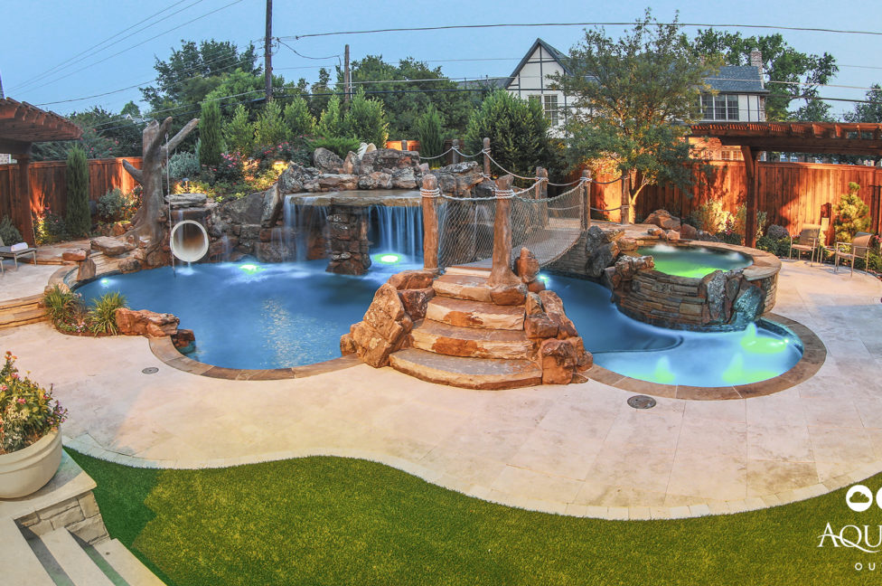 In ground pool with water slide and rope bridge