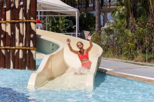 teen girl sliding down pool slide
