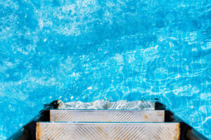 Child splashing in the cool water of a pool in summer