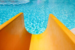Step with slide in the pool by the sea nature background. For bathing turquoise water.