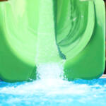 Green slide in water park. Summer vacation