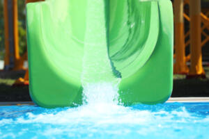 Green slide in water park. Summer vacation