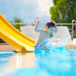 cute boy kid having fun on water slide